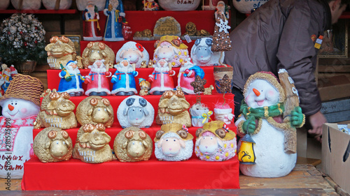 Christmas tree decorations made of glass, wood and fabric of different shapes and colors on the counter at the festive fair