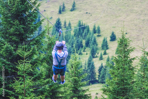 Descent from the mountain on a metal cable. Zipline is an extreme kind of fun in nature_