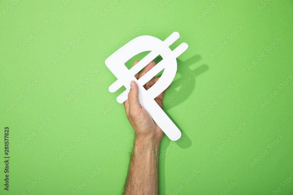 cropped view of man holding white peso currency sign on green - obrazy, fototapety, plakaty 