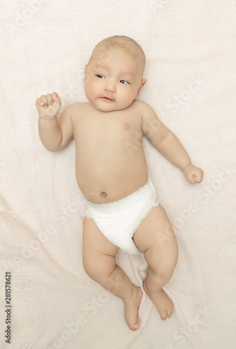 Cute baby child lying in bed with white blanket