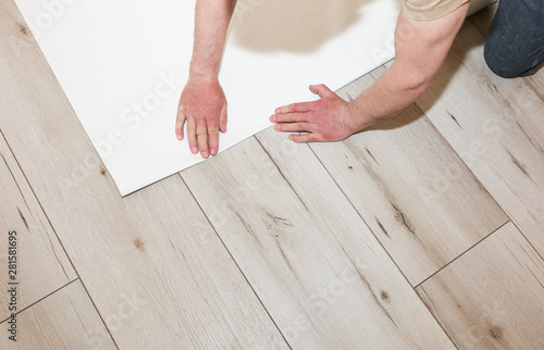 Man is holding roll wallpaper in hands on floor. Maintenance repair works renovation in the flat. Restoration indoors.