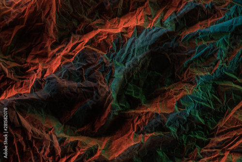 top view of crumpled textured paper with multicolored lighting