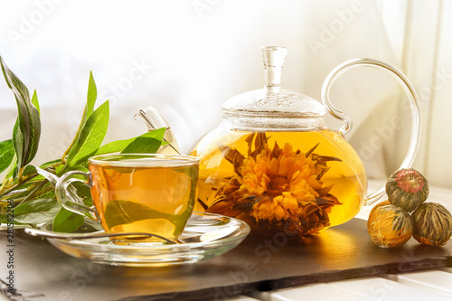 Exotic green tea with flowers in glass teapot