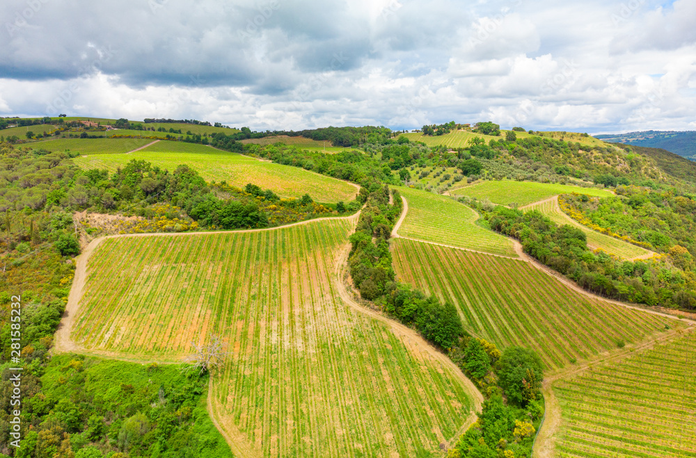 Aerial view of a vineyard and hotel in the green landscape of Tuscany Italy