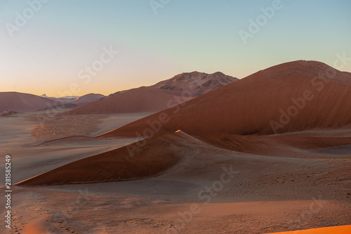 Early morning sunlight illuminating the red sand of Namibias sussusvlei
