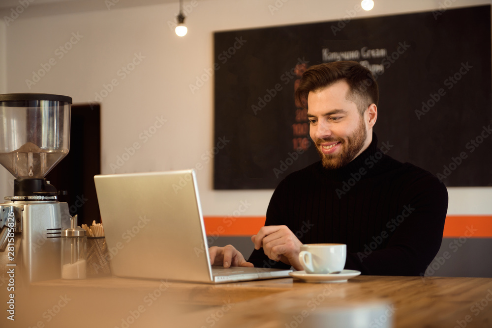 Businessman using laptop with tablet on wooden table in coffee shop with a cup of coffee. Businessman using laptop with tablet on wooden table in coffee shop with a cup of coffee.