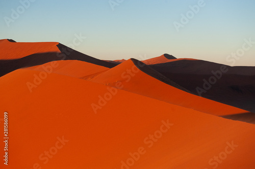 Early morning sunlight illuminating the red sand of Namibias sussusvlei