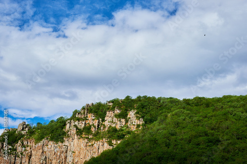 View of mountain snowy ridges on a bright sunny day with clouds in the sky.