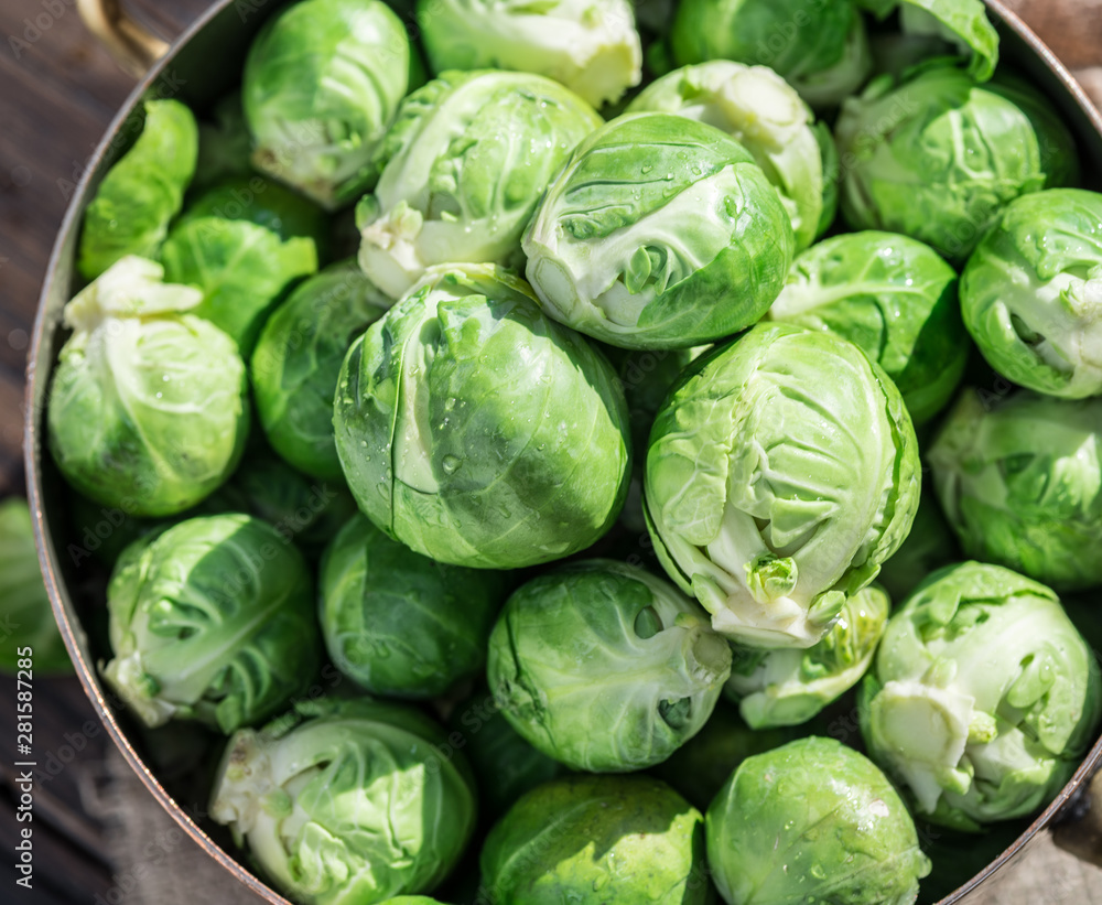 Fototapeta premium Brussel sprouts in the copper pan on the old wooden table.