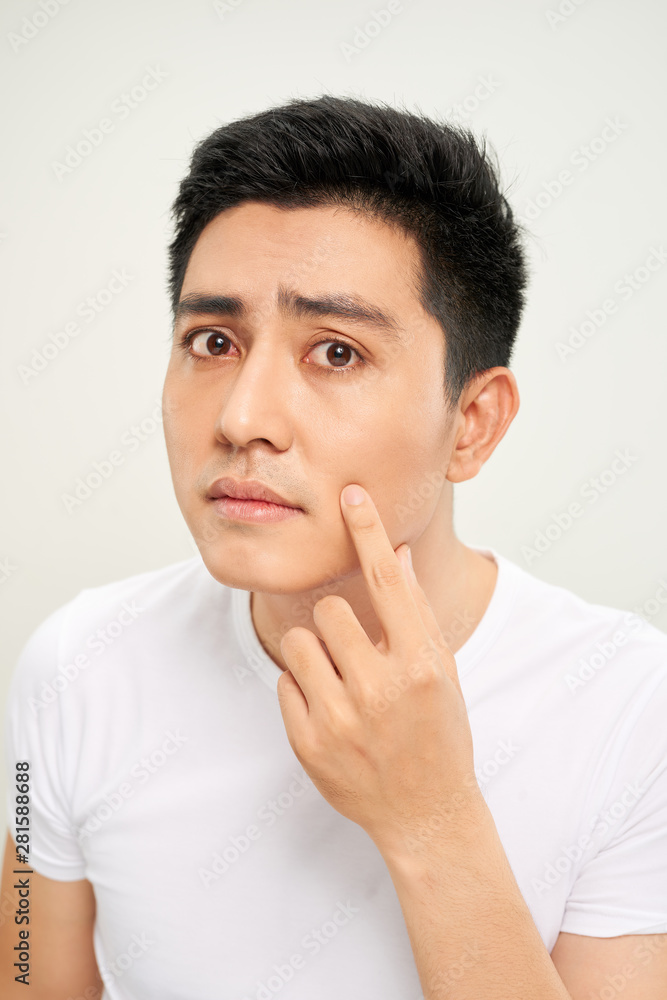 Close up photo of young man looking for acnes on his face Close up photo of young man looking for acnes on his face