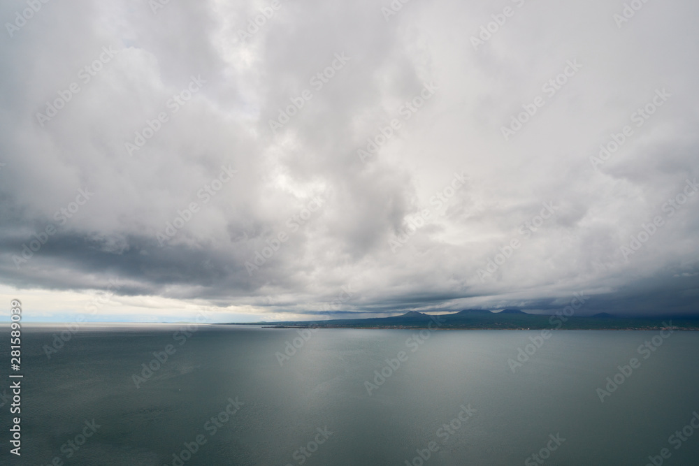 the endless water expanses of the lake Sevan on a cloudy day with clouds in the sky.