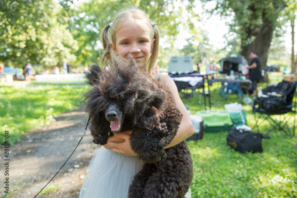 Child blond girl lovingly embraces his pet Poodle dog. Friendship. Child blond girl lovingly embraces his pet Poodle dog. Friendship.