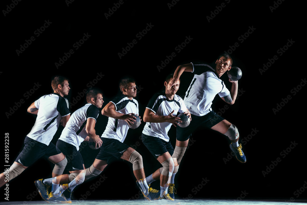 Caucasian young handball player in action and motion in mixed and strobe light on black studio background. Fit professional sportsman. Concept of sport, movement, energy, dynamic, healthy lifestyle.