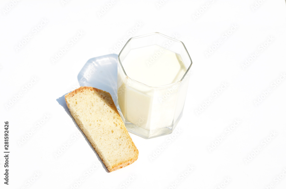 Glass of milk and a piece of bread isolated on white background,dairy product,photo Glass of milk and a piece of bread isolated on white background,dairy product,photo