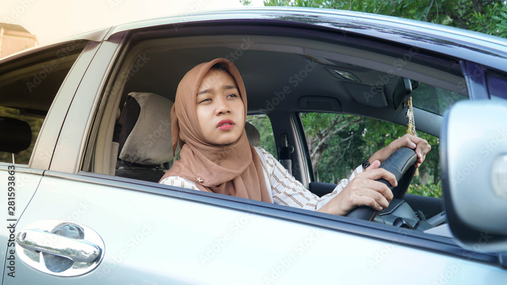 portrait of young Muslim hijab women while driving a car looking forward