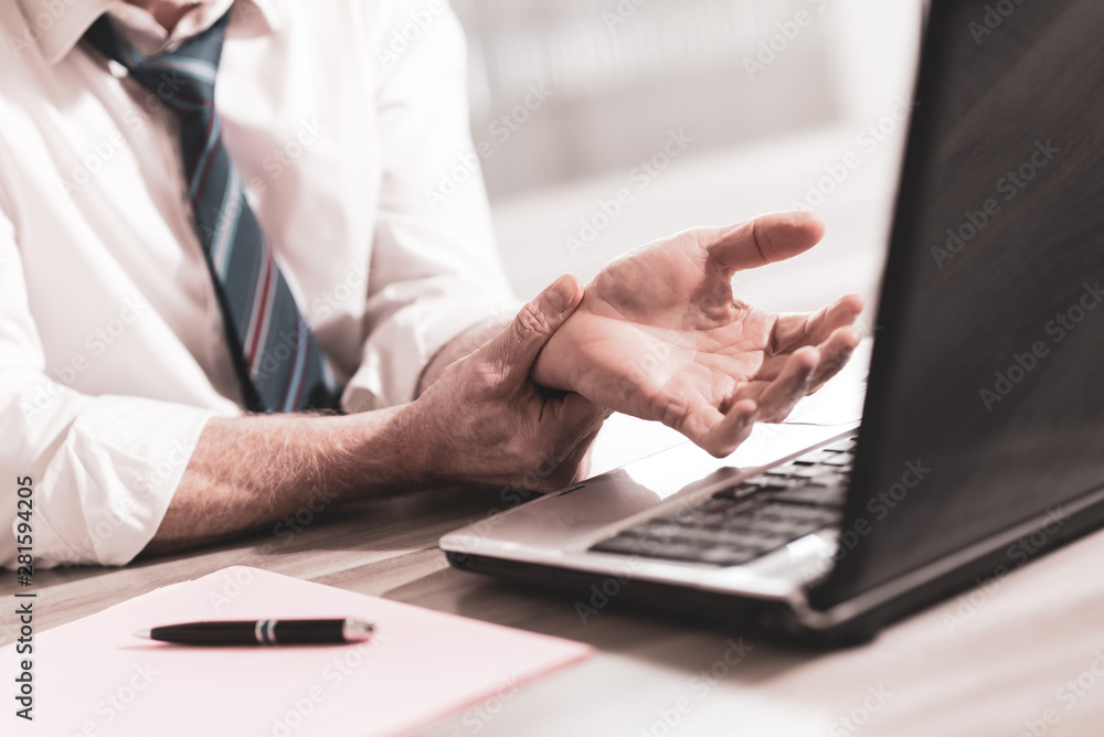 Businessman suffering from wrist pain Businessman suffering from wrist pain