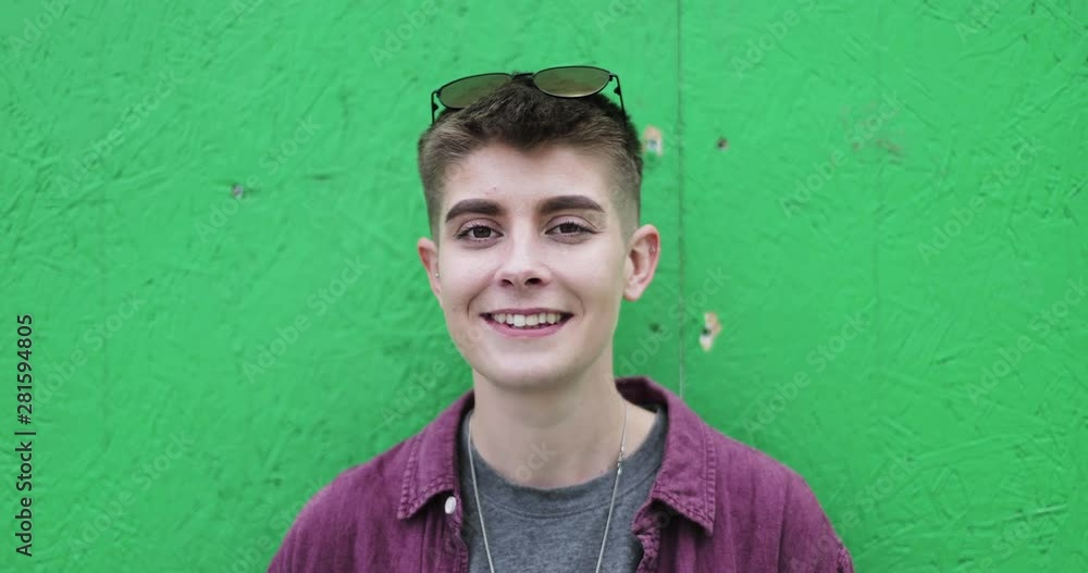 Portrait of gender neutral young adult with green background Portrait of gender neutral young adult with green background