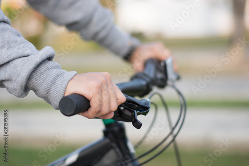 close up shot of hijab woman's hand was holding the wheel of a bicycle in a park