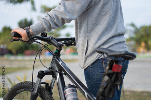 close up shot of hijab woman's hand was holding the wheel of a bicycle from behind in a park