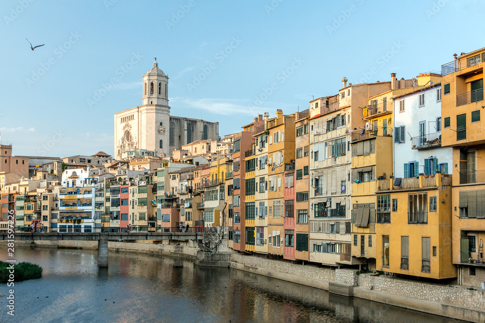 Cathedral of Girona, colorful houses and Onyar river under blue sky