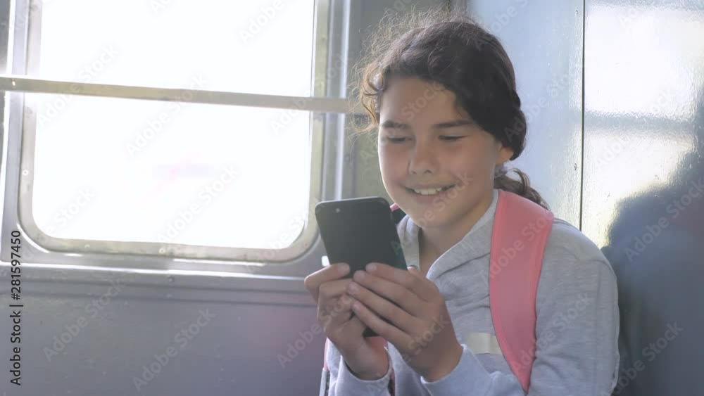 Teenager girl traveler with a backpack sitting on bags backpacks at the window of the car with a smartphone. Travel rail carriage concept. the girl in the train lifestyle at the window corresponds to Teenager girl traveler with a backpack sitting on bags backpacks at the window of the car with a smartphone. Travel rail carriage concept. the girl in the train lifestyle at the window corresponds to