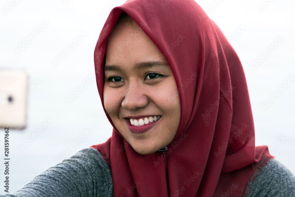 close-up shot of photos of hijab women selfie facing the camera while laughing close-up shot of photos of hijab women selfie facing the camera while laughing