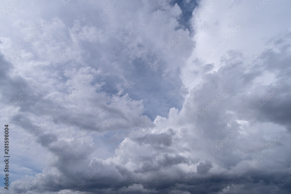 Obraz premium Towering cumulonimbus clouds accompanied by smaller cumulus clouds