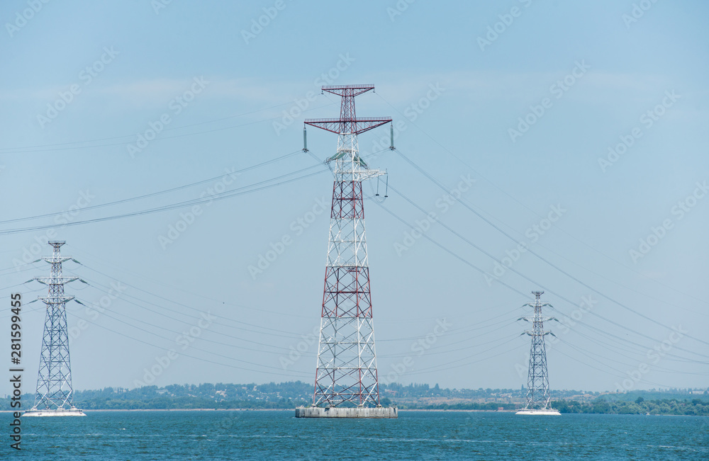 High-voltage pylons of power lines on the river
