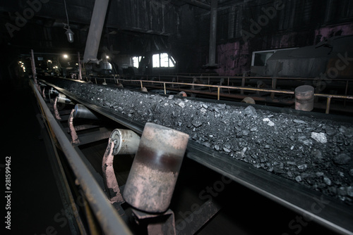 Black coal on a conveyor belt. The production process in the Thermal Power Plant. photo