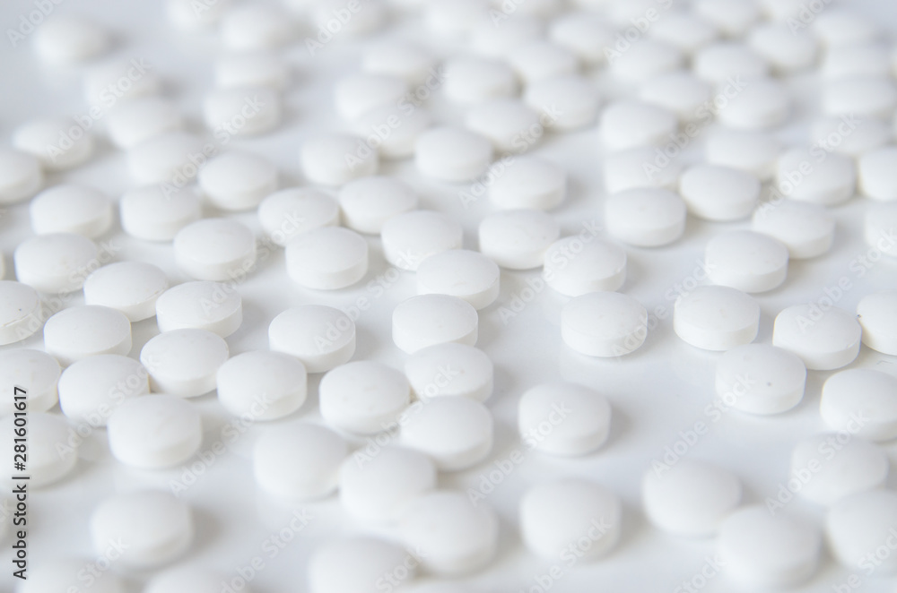 scattered white pills on the white table scattered white pills on the white table