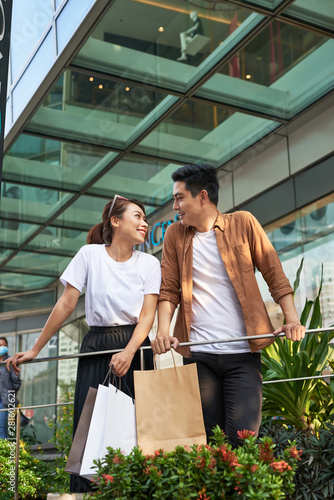 Beautiful young loving couple carrying shopping bags and enjoying together.