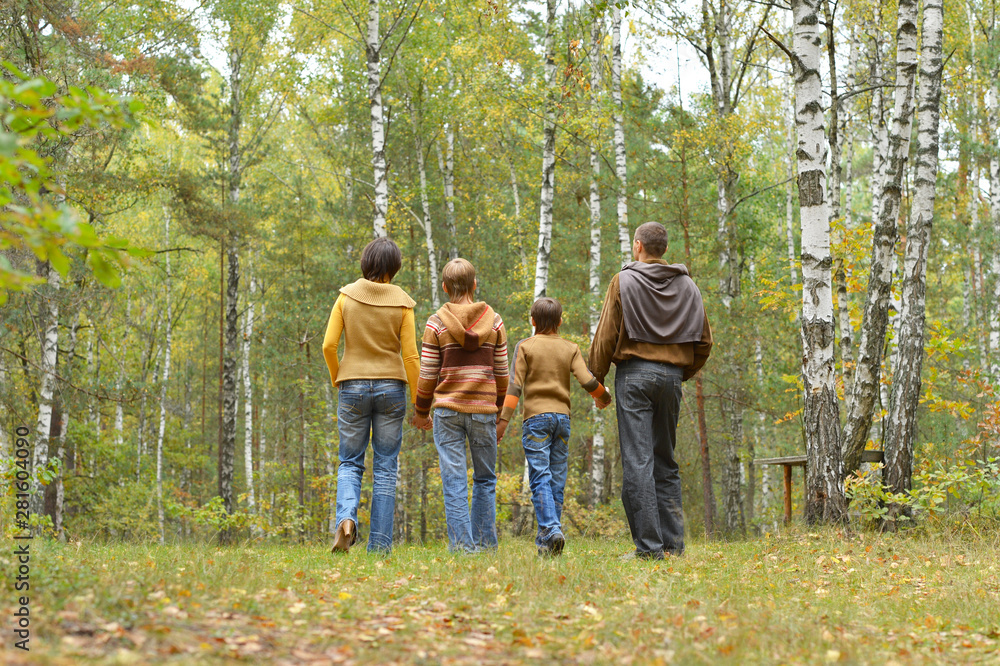 Portrait of family of four having fun in autumn forest