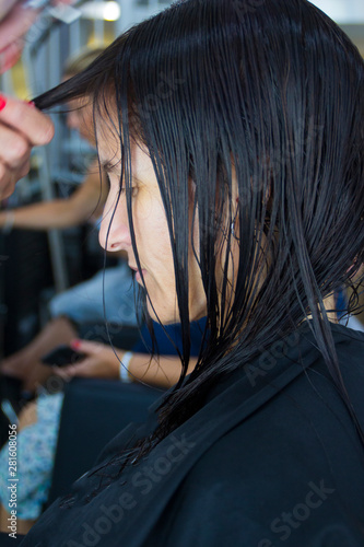 Close up of hairstylist cutting brown hair © elenaara