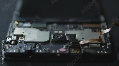 Close-up of a cell phone repair. The internal components of a smartphone. Disassembled cell phone. Cell Phone Battery. Master disassembled mobile device for detail. Chips and details of the smartphone