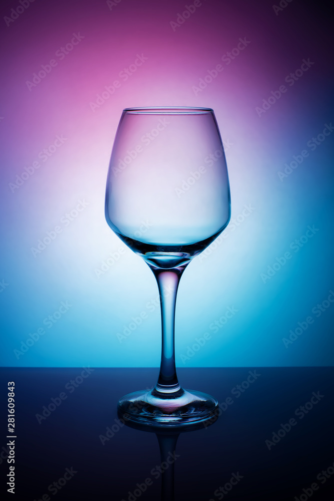 Wine glass on a purple white blue background.