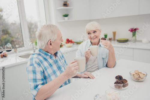 Portrait of sweet cute old lady man sit table telling speaking saying talking hold hand beverage pastry indoors