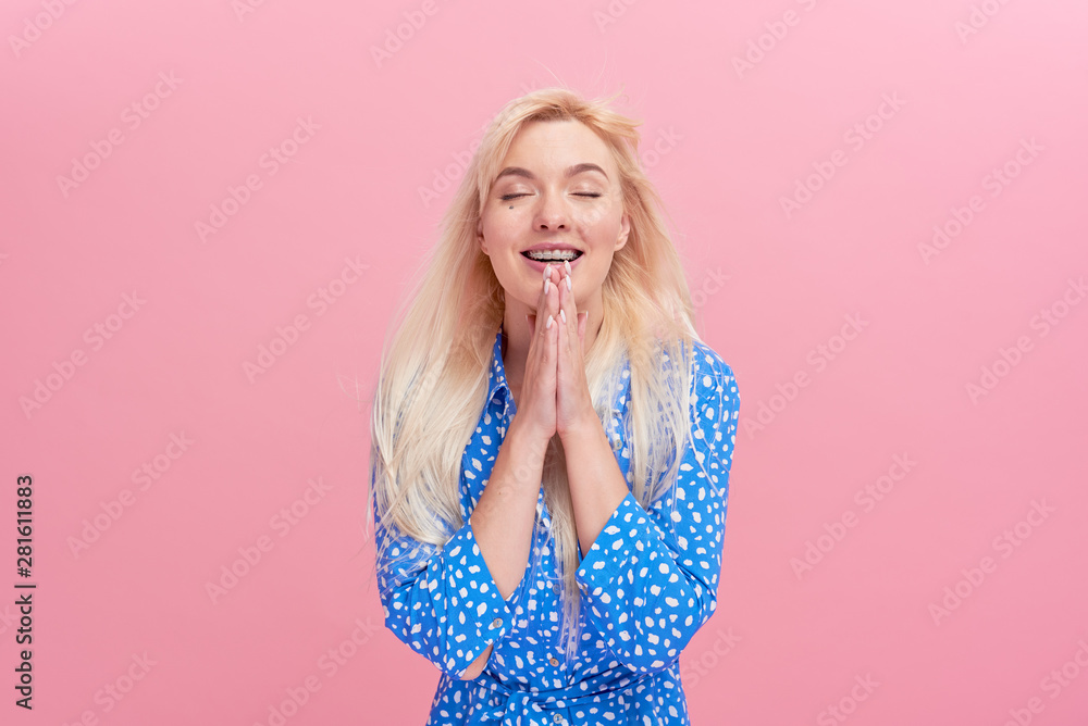 Portrait of shocked excited young blond woman in bright dress standing isolated over pink background. Looking camera. Hands near open mouth Portrait of shocked excited young blond woman in bright dress standing isolated over pink background. Looking camera. Hands near open mouth