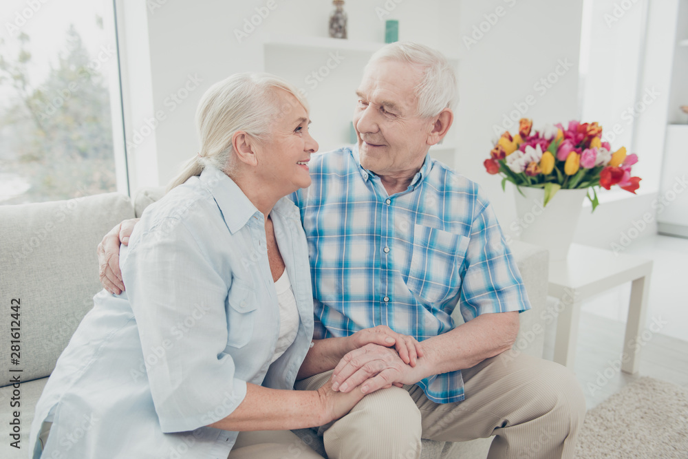 Portrait of her she his he two nice attractive sweet tender gentle cheerful peaceful calm romantic spouses holding hands sitting on divan feelings in light white interior room indoors Portrait of her she his he two nice attractive sweet tender gentle cheerful peaceful calm romantic spouses holding hands sitting on divan feelings in light white interior room indoors