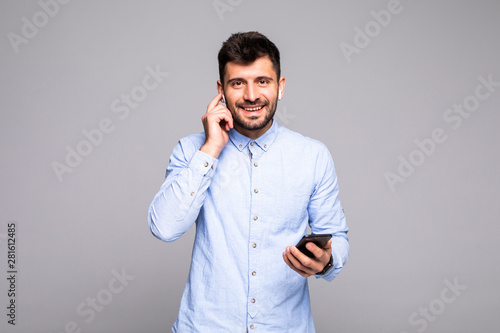 Young handsome man talk vie air beans on the phone isolated on gray background © F8  \ Suport Ukraine