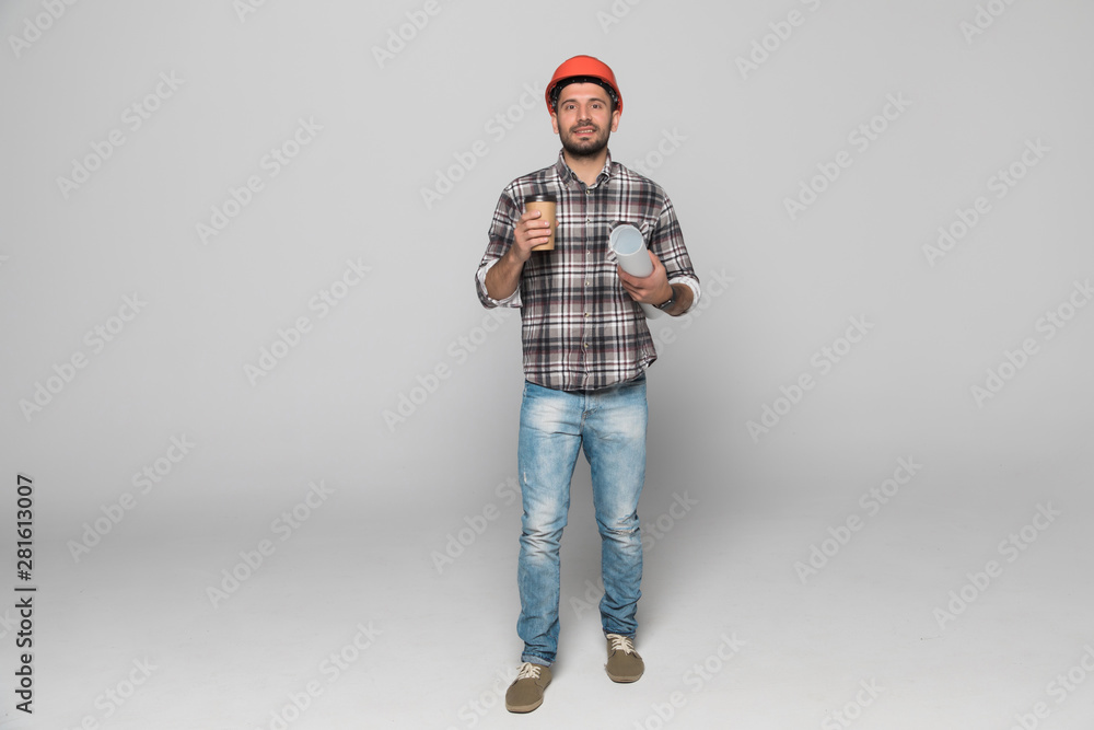 Portrait of young architect with yellow helmet drinking coffee isolated on white background Portrait of young architect with yellow helmet drinking coffee isolated on white background