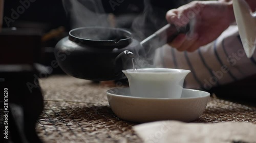 Traditional Chinese gongfu or kung fu tea ceremony. Boiling water pours into gaiwan. Tea master pours the water into gaiwan or zhong with green tea. Element of traditional Chinese culture. Closeup. 4k