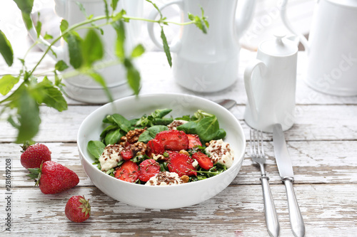 Salad with strawberries, ricotta cheese and green lettuce with walnuts and balsamic dressing