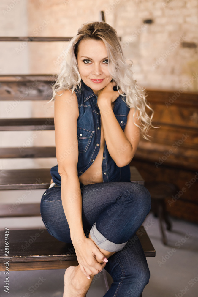 Beautiful sexy blonde in jeans and a denim vest foto de Stock | Adobe Stock