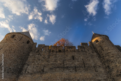 High castle towers, stone wall, clouds & sky