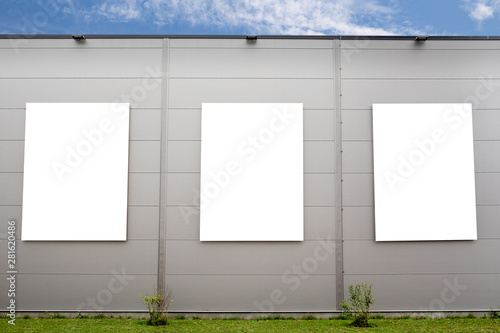 Three big vertical poster on the grey building. Empty advertising frame  mockup