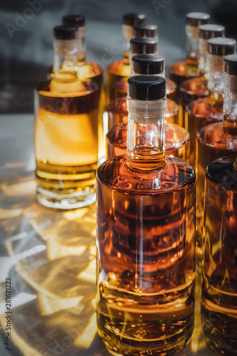 Small liquor production based on maple syrup. Multitude of pure alcohol bottles not labeled. Bottles placed in a row.