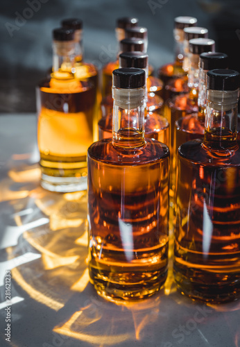 Small liquor production based on maple syrup. Multitude of pure alcohol bottles not labeled. Bottles placed in a row.