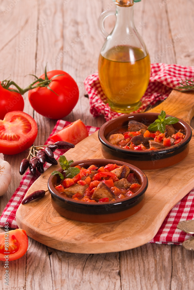 Marinated pork loin in tomato sauce.