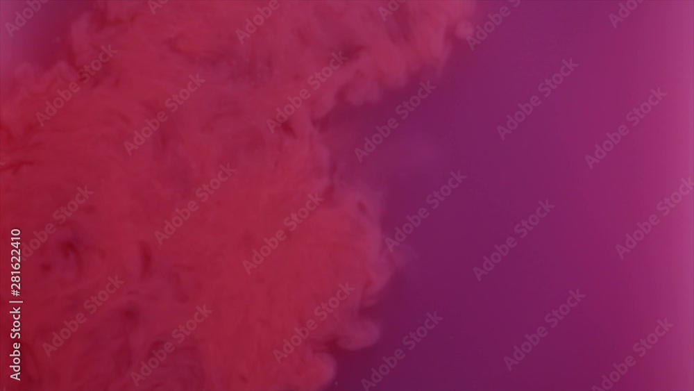 Pouring of beautiful coral ink into water with purple dye Pouring of beautiful coral ink into water with purple dye