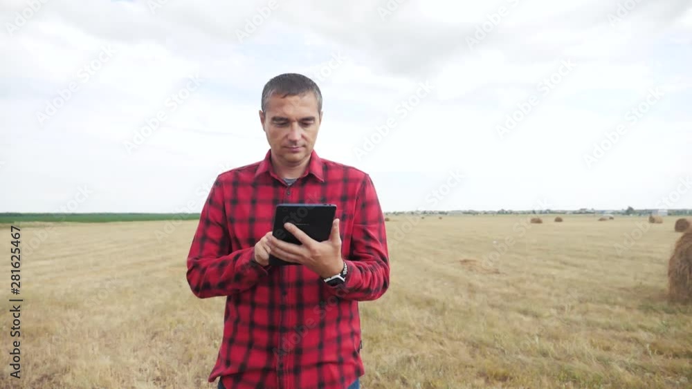 smart farming agriculture concept. man farmer studying a haystack in a field on digital tablet. slow motion video. lifestyle male agronomist botanist farmer working in the field smart farming agriculture concept. man farmer studying a haystack in a field on digital tablet. slow motion video. lifestyle male agronomist botanist farmer working in the field